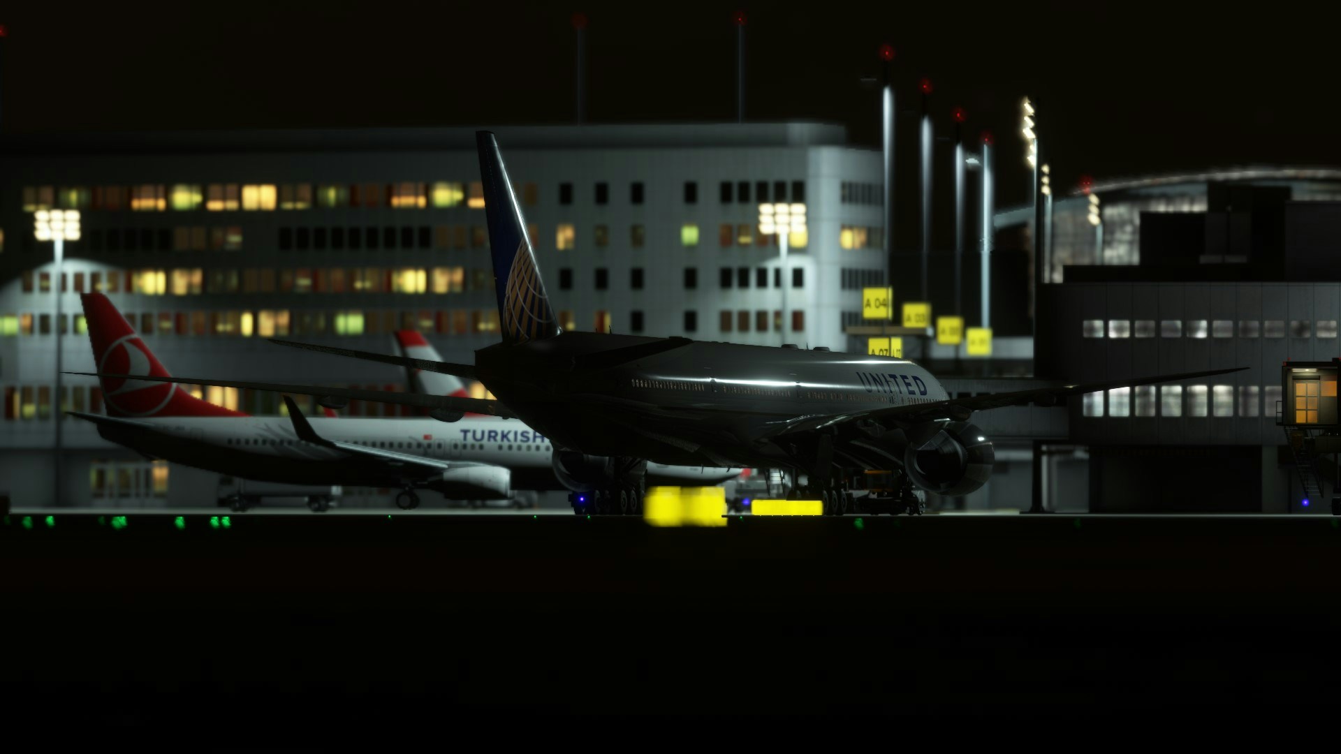 2 airliners parked on stand at night